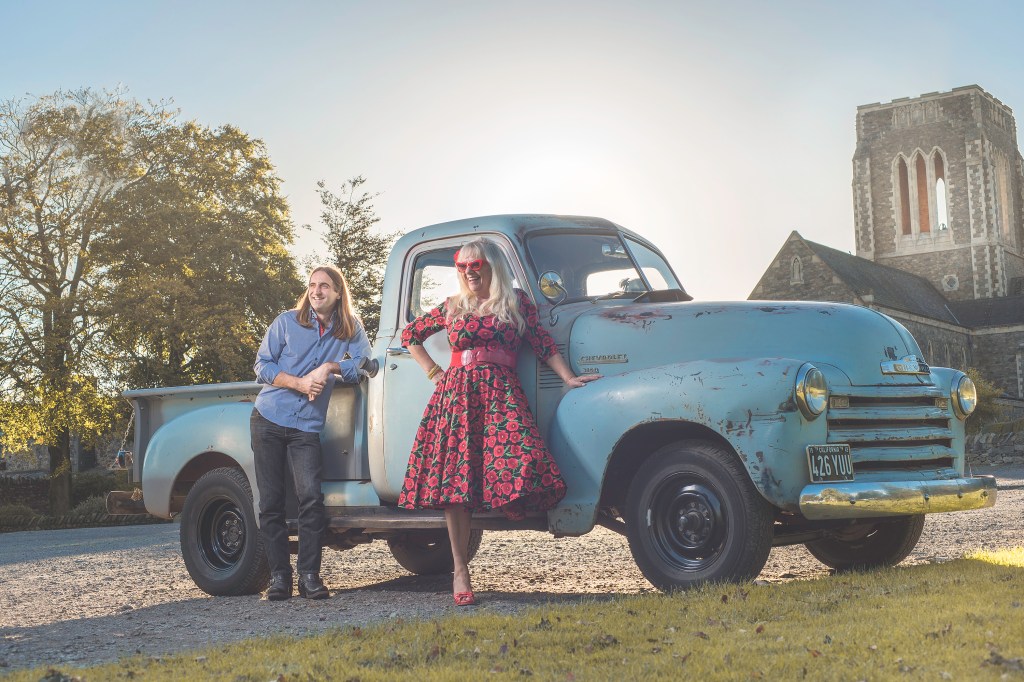 A truck is parked in front of a blue car

Description automatically generated