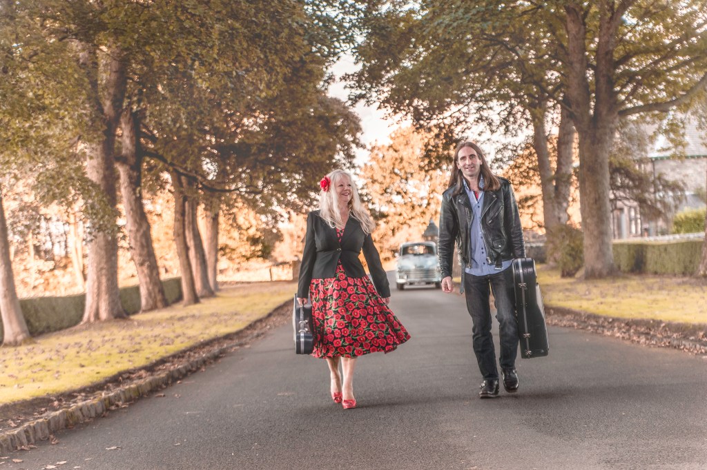 A person walking down a street next to a tree

Description automatically generated